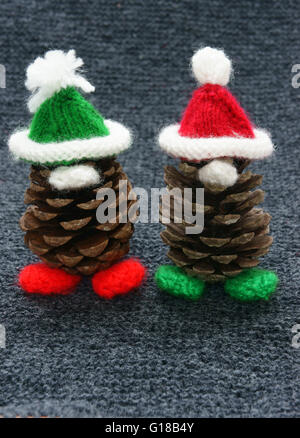 Pino natale gnome, pigna usura Xmas hat per la decorazione sulla vacanza invernale, con rosso, verde filati, prodotti artigianalmente da lavorate a maglia Foto Stock