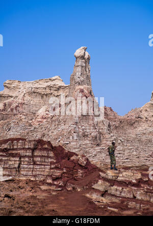 Soldato etiope nel sale canyon formato da strati di Alite e gesso nella depressione di Danakil, regione di Afar, Dallol, Ethiop Foto Stock