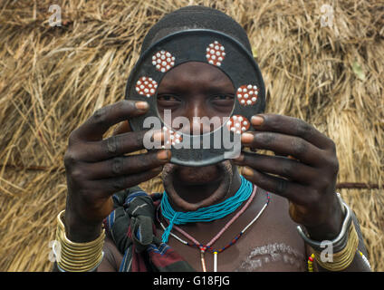 Un Mursi tribeswoman tenendo un tradizionale labbro di piastra, valle dell'Omo, parco di Mago, Etiopia Foto Stock