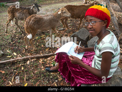 Rastafari ragazza chiamato disegno kizzy pecore in un giardino di Oromo, Shashamane, Etiopia Foto Stock