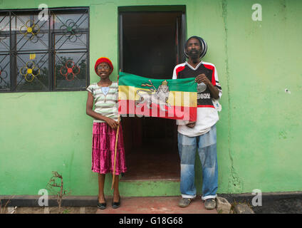 Rastafari ragazza chiamato kizzy tenendo una bandiera con suo padre, Oromo, Shashamane, Etiopia Foto Stock