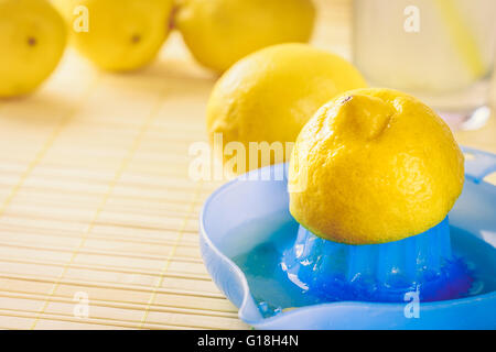 Blu centrifuga di limone con il limone sulla parte superiore su sfondo di legno. Spazio di copia Foto Stock