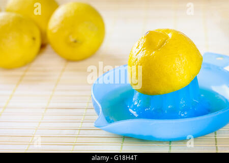 Blu centrifuga di limone con il limone sulla parte superiore su sfondo di legno. Spazio di copia Foto Stock