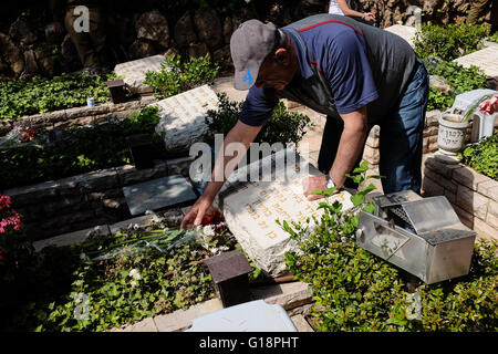 Gerusalemme, Israele. 11 Maggio, 2016. Famiglie, amici e camerati in armi pay rispetta e piangono i caduti presso il monte Herzl Cimitero Militare durante Yom Hazikaron Memorial Day. Questo giorno memoriale commemora 23,477 soldati caduti e le donne e 2,576 vittime del terrore. Credito: Nir Alon/Alamy Live News Foto Stock