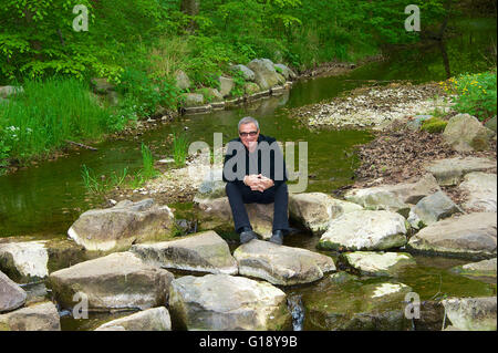 Seeshaupt, Germania. Il 10 maggio, 2016. dpa esclusivo - Tico Torres, batterista di Bon Jovi, siede tra rocce dopo una presentazione del suo "Rock Star Baby' collezione di moda al Lupaco Concept Store in Seeshaupt, Germania, 10 maggio 2016. Foto: Ursula Dueren/dpa/Alamy Live News Foto Stock