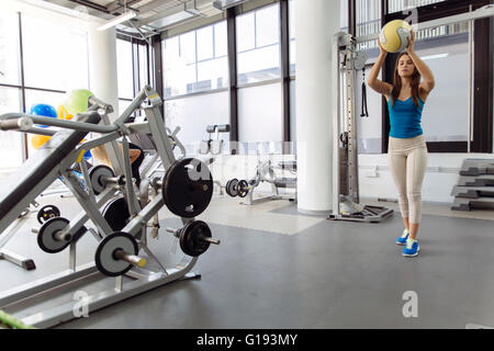 Bella donna formazione in palestra e mantenendo il corpo in forma Foto Stock