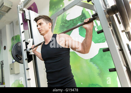 Uomo bello formazione in palestra per mantenersi in forma e forte Foto Stock