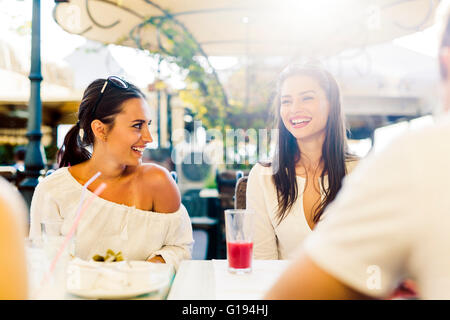 Due giovani ragazze a parlare e sorridente durante la pausa pranzo Foto Stock