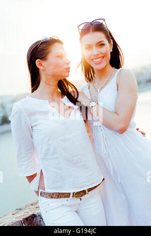 Giovani e belle donne di sorridere e di essere felice mentre vestita di bianco Foto Stock