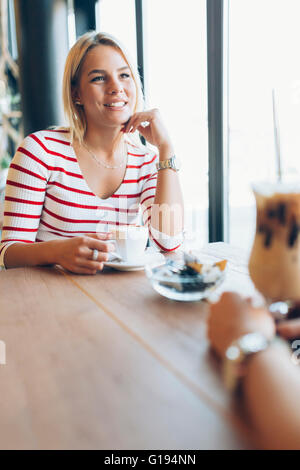 Belle Donne a bere caffè e spettegolare nel bel ristorante Foto Stock