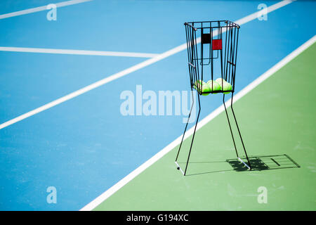Bellissimo campo da tennis con una palla canestro e palle da tennis in esso Foto Stock