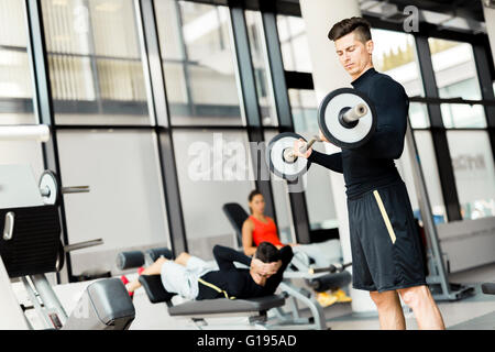 Giovane uomo bello la formazione in un centro fitness Foto Stock