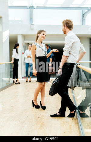 Colleghi di lavoro parlando casualmente nella costruzione di essi opera in Foto Stock