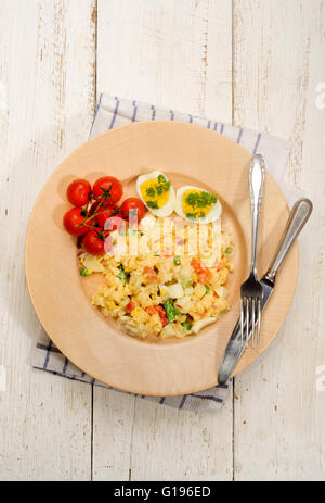 Vegetariano misti insalata di pasta con uova e verdure su un piatto di legno Foto Stock