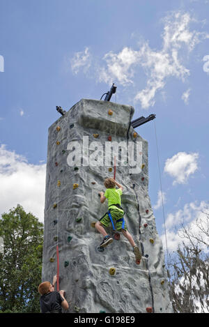 Cercando di raggiungere la parte superiore di una parete da arrampicata e di suonare il campanello del successo di segnalazione. A Pioneer giorni celebrazione annuale in alta Spri Foto Stock