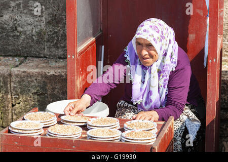 Donna vendita di cibo per piccioni presso la Nuova Moschea, Eminonu Yeni Camii, Eminonu, Istanbul, Turchia Foto Stock