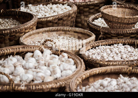 Cesti lavorati a mano piena di bulbi di aglio in vendita su un tradizionale mercato indiano Foto Stock