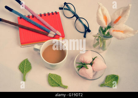 Romantiche escursioni con ornamento dal prodotto artigianale, giglio fiore a maglia di filati, handbook, maglia matita, tazza di caffè, bicchieri Foto Stock