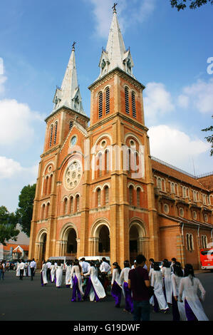 HO CHI MINH CITY, VIET NAM, la folla di studenti vietnamiti in abito tradizionale, ao dai, a Saigon la cattedrale di Notre Dame, Vietnam Foto Stock