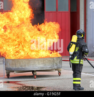 I vigili del fuoco con bombole ossigeno spegnere il fuoco durante un esercizio di formazione Foto Stock