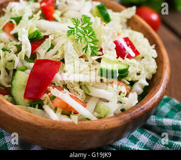 Vegetariano insalata di verdure (cavolo, pomodoro, la paprika, il cetriolo, la cipolla) in una ciotola di legno Foto Stock