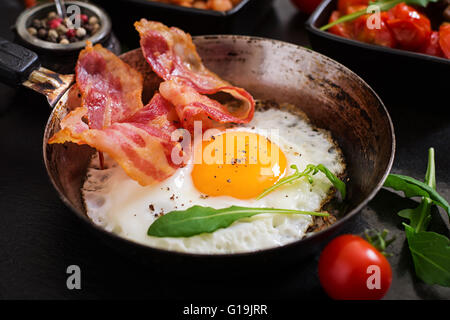 Prima colazione inglese - uovo fritto, fagioli, pomodori, funghi, bacon e toast Foto Stock
