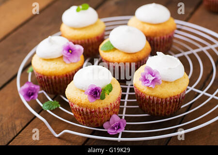 Cottage cheese tortine di meringa ornato di fiori e foglie di menta Foto Stock