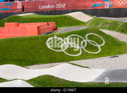 Anelli olimpici dipinta su una banca erbosa presso la pista di BMX, Olympic Park, Stratford, Londra Foto Stock