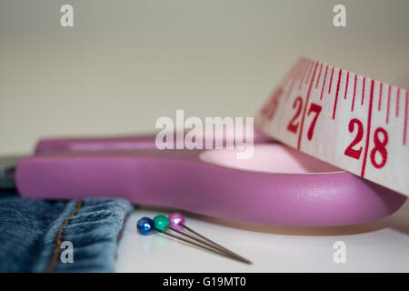 Close-up immagine di forbici, panno, perni e nastro di misurazione Foto Stock