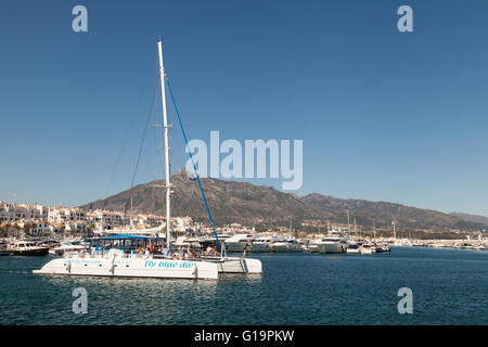 Catamarano a vela vela fuori Puerto Banus harbour con la Costa del Sol i turisti, Marbella, Andalusia, Spagna, Europa Foto Stock