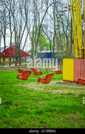 Molla di vuoto il vecchio parco di divertimenti, catena giostra swing attende i visitatori, (filtrato per LoMo effetto) Foto Stock