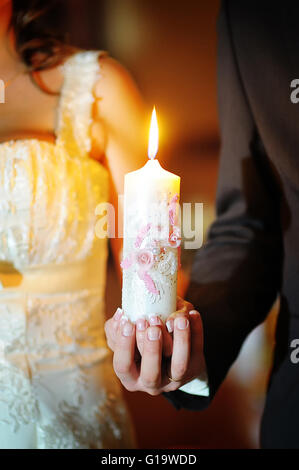 Lo sposo e la sposa con le candele. Cerimonia di matrimonio in chiesa Foto Stock