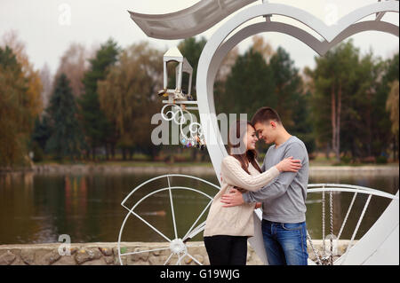 Affettuosa coppia giovane in piedi insieme al parco ragazza smi Foto Stock