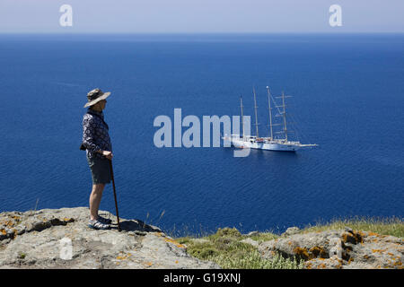 Adulto turista gode la vista mozzafiato di Myrinas' castello affacciato sul ancorato Star Clipper a vela nel mare Egeo Foto Stock