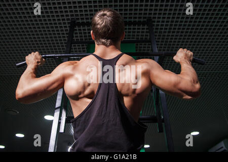 Forte uomo muscolare facendo tirare ups su bar Foto Stock