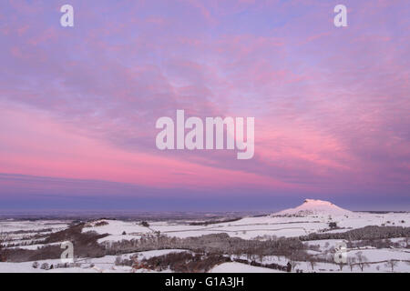 Roseberry Topping allo spuntar del giorno in inverno, la neve e il cloud prelievo di alba di colori Foto Stock