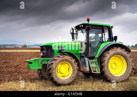 Karlovo, Bulgaria - Agosto 22th, 2015: aratura di un campo con John Deere trattore 6930. John Deere 8100 è stato fabbricato nel 1995- Foto Stock