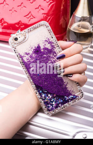 Femmina lato tenendo una custodia per telefono Foto Stock