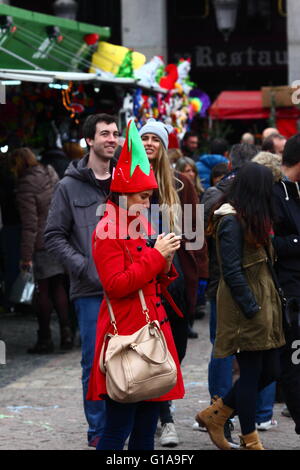 Donna che indossa il costume di Elf controlla i messaggi sul suo smartphone nel mercato di Natale, Plaza Mayor, Madrid, Spagna Foto Stock
