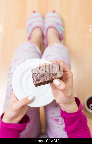 Donna di mangiare il biscotto prospettiva in prima persona Foto Stock