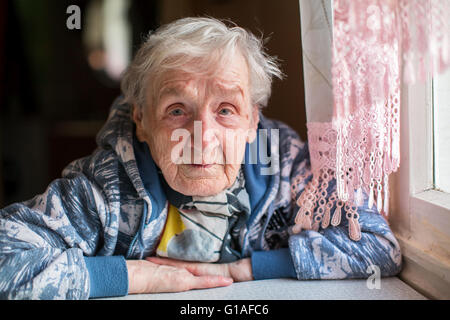 Triste donna anziana ritratto al tavolo. Foto Stock