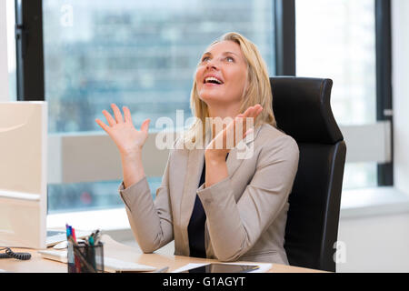 Felice donna d'affari di successo in ufficio. Costruzione di sfondo Foto Stock