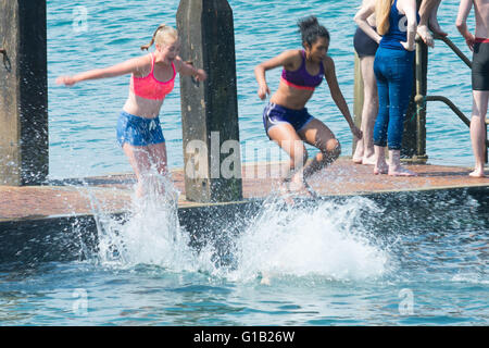 Aberystwyth, Wales, Regno Unito, giovedì 12 maggio 2016 UK Meteo: persone al mare in Aberystwyth godendo di nuoto e divinf in mare l'ultimo giorno di caldo meteo attuale mini ondata di caldo. Le temperature sono impostate a cadere nei prossimi giorni, con luminosa ma più freddo a condizioni che prevalgono nel paese Photo credit: Keith Morris / Alamy Live News Foto Stock