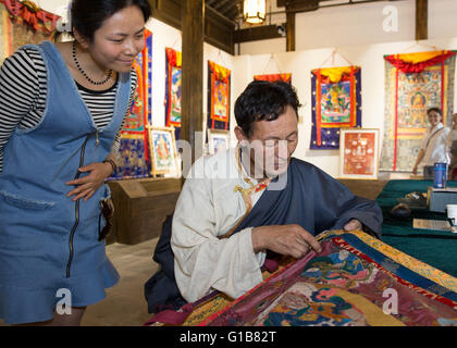 Nanjing, Nanjing, CHN. Il 12 maggio 2016. Nanjing, Cina - 12 Maggio 2016: (solo uso editoriale. Cina OUT ) mostra Thangka dalla contea Gongka Mozhu Yibet in Nanjing il Giardino di Yu. Un thangka, variamente spelta come tangka, thanka o tanka (pronuncia nepalese: [?t??un?ka]; il Tibetano: ?????; Nepal Bhasa: ????) è un buddista tibetano dipinto su cotone o seta appliquÂ¨â ¦, solitamente raffigurante una divinità buddista, scena o mandala. Thangkas sono tradizionalmente mantenuto privo di cornice e arrotolato quando non è sul display, montato su un supporto di materie tessili un po' in stile cinese dipinti di scorrimento, con un ulteriore coperchio di seta Foto Stock