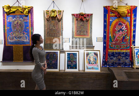 Nanjing, Nanjing, CHN. Il 12 maggio 2016. Nanjing, Cina - 12 Maggio 2016: (solo uso editoriale. Cina OUT ) mostra Thangka dalla contea Gongka Mozhu Yibet in Nanjing il Giardino di Yu. Un thangka, variamente spelta come tangka, thanka o tanka (pronuncia nepalese: [?t??un?ka]; il Tibetano: ?????; Nepal Bhasa: ????) è un buddista tibetano dipinto su cotone o seta appliquÂ¨â ¦, solitamente raffigurante una divinità buddista, scena o mandala. Thangkas sono tradizionalmente mantenuto privo di cornice e arrotolato quando non è sul display, montato su un supporto di materie tessili un po' in stile cinese dipinti di scorrimento, con un ulteriore coperchio di seta Foto Stock