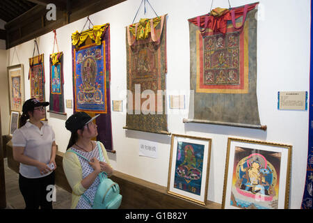 Nanjing, Nanjing, CHN. Il 12 maggio 2016. Nanjing, Cina - 12 Maggio 2016: (solo uso editoriale. Cina OUT ) mostra Thangka dalla contea Gongka Mozhu Yibet in Nanjing il Giardino di Yu. Un thangka, variamente spelta come tangka, thanka o tanka (pronuncia nepalese: [?t??un?ka]; il Tibetano: ?????; Nepal Bhasa: ????) è un buddista tibetano dipinto su cotone o seta appliquÂ¨â ¦, solitamente raffigurante una divinità buddista, scena o mandala. Thangkas sono tradizionalmente mantenuto privo di cornice e arrotolato quando non è sul display, montato su un supporto di materie tessili un po' in stile cinese dipinti di scorrimento, con un ulteriore coperchio di seta Foto Stock