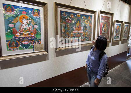 Nanjing, Nanjing, CHN. Il 12 maggio 2016. Nanjing, Cina - 12 Maggio 2016: (solo uso editoriale. Cina OUT ) mostra Thangka dalla contea Gongka Mozhu Yibet in Nanjing il Giardino di Yu. Un thangka, variamente spelta come tangka, thanka o tanka (pronuncia nepalese: [?t??un?ka]; il Tibetano: ?????; Nepal Bhasa: ????) è un buddista tibetano dipinto su cotone o seta appliquÂ¨â ¦, solitamente raffigurante una divinità buddista, scena o mandala. Thangkas sono tradizionalmente mantenuto privo di cornice e arrotolato quando non è sul display, montato su un supporto di materie tessili un po' in stile cinese dipinti di scorrimento, con un ulteriore coperchio di seta Foto Stock