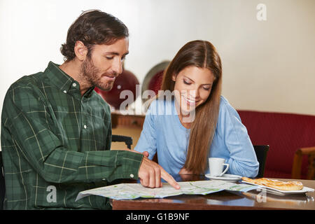 Matura in hotel guardando la mappa della città durante le proprie vacanze Foto Stock