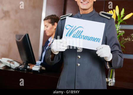Pagina in hotel reception azienda segno tedesco dicendo "Willkommen" (Benvenuti) Foto Stock