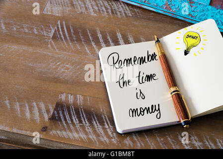 Il testo scritto a mano ricorda il tempo è denaro con penna stilografica sul notebook. Concetto di immagine con copia spazio disponibile. Foto Stock